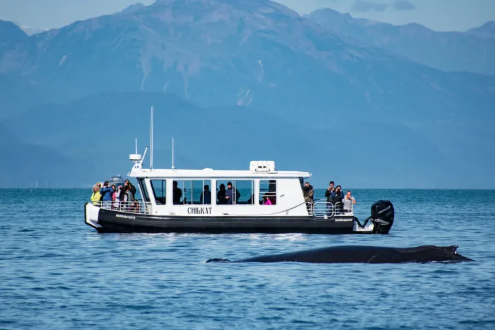 a small boat in a body of water with a mountain in the background