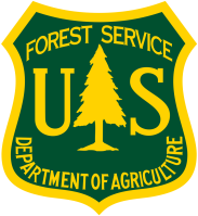 U.S. Forest Service emblem with tree silhouette on dark green background.